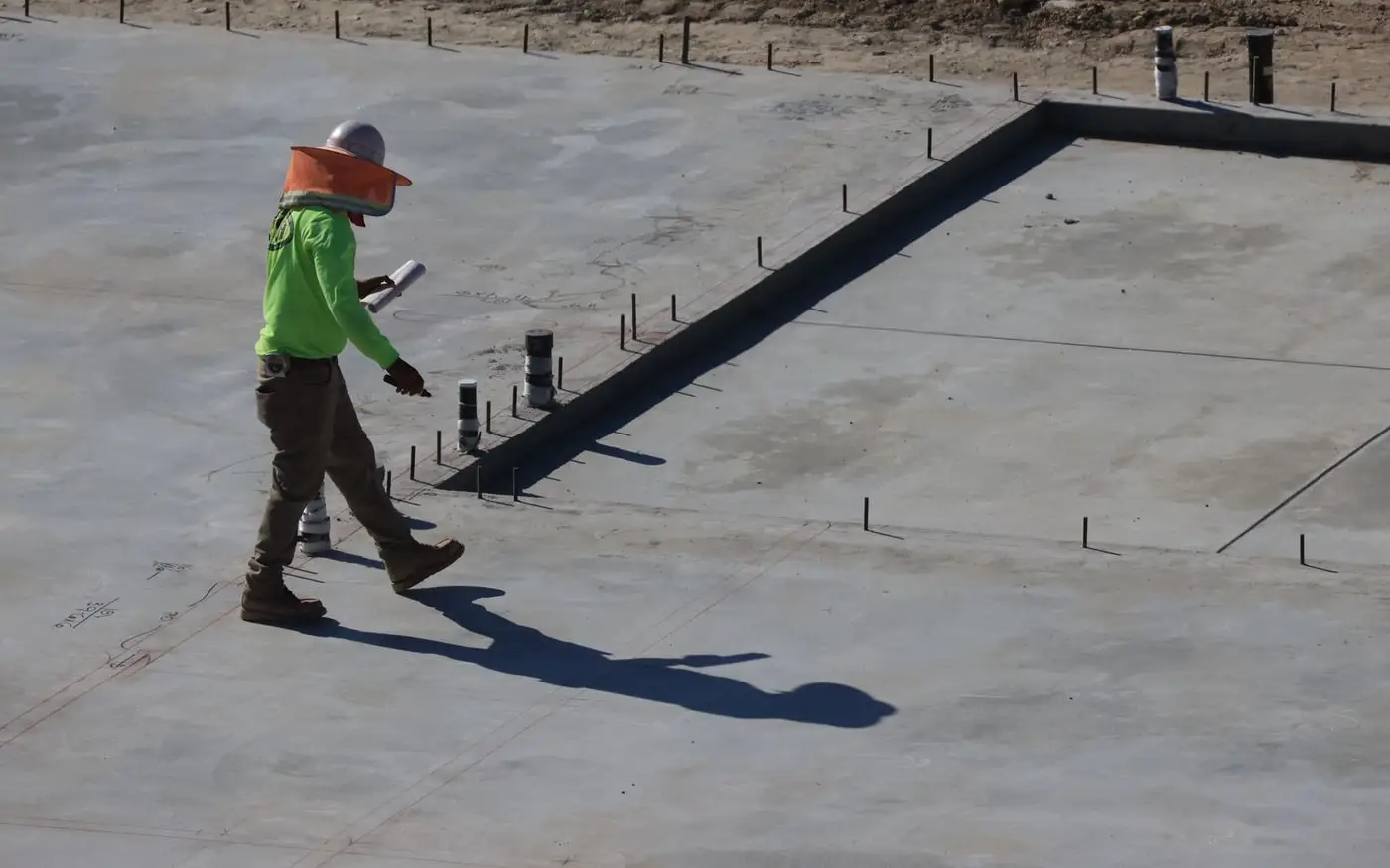 Técnico revisando una losa de hormigón en una obra Técnico revisando una losa de hormigón en una obra