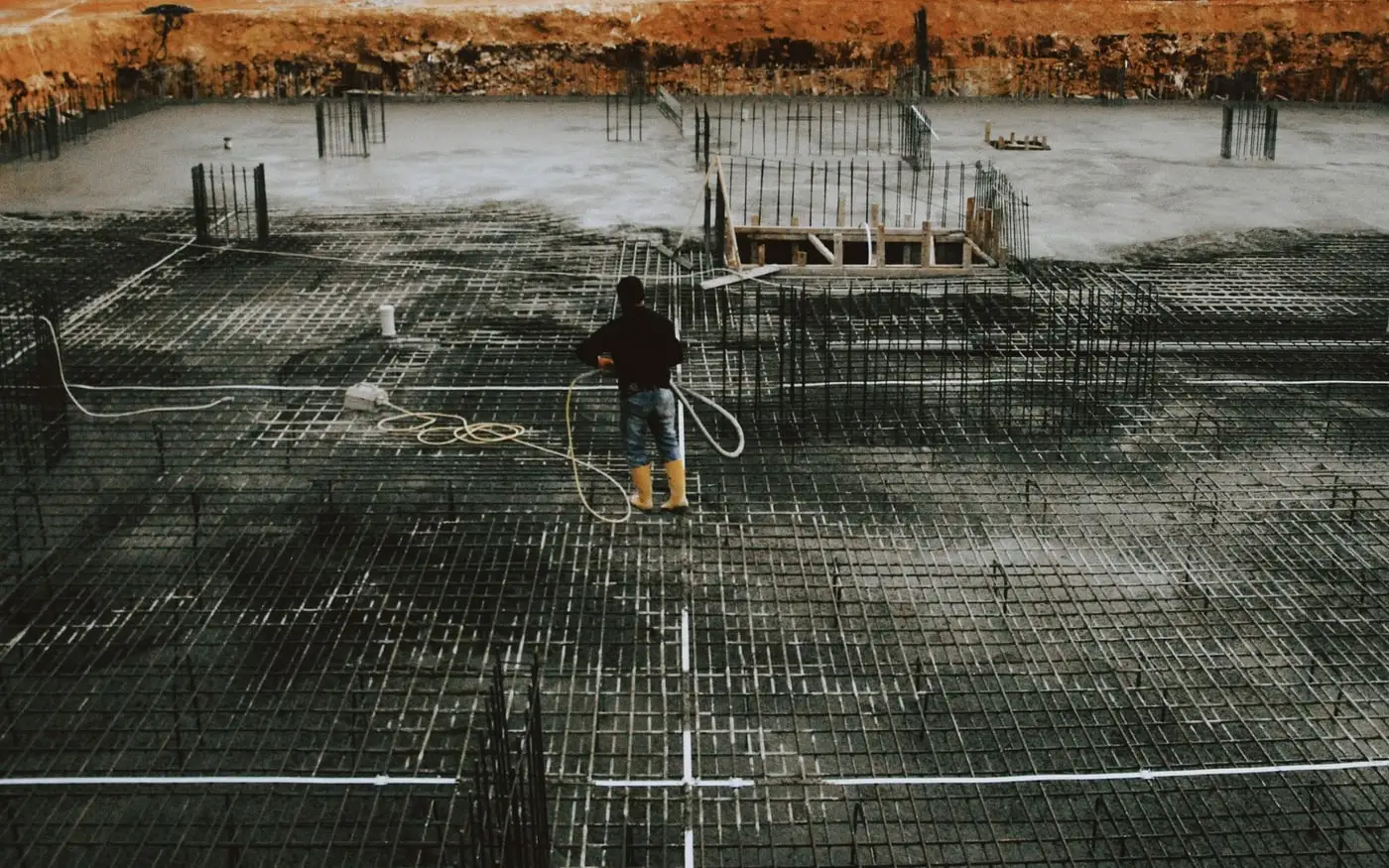 Operario revisando la armadura de una cimentación antes del hormigonado Operario revisando la armadura de una cimentación antes del hormigonado